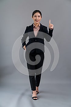 Confident young asian businesswoman in formal suit pointing finger. Enthusiastic
