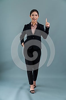 Confident young asian businesswoman in formal suit pointing finger. Enthusiastic