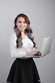 Confident young asian woman holding laptop