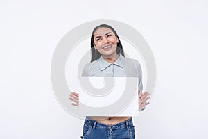 A confident young Asian woman smiling pleasantly while holding a white blank signage. Isolated on a white background