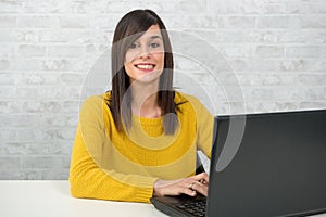 Confident young beautiful businesswoman with laptop at office