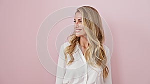 Confident young blonde woman, all smiles, fashionably wearing shirt over pink background, looking away and laughing with natural