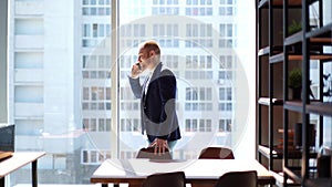 Confident young business man talking on mobile phone in modern meeting office