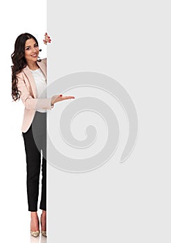 Confident young business woman presenting blank board