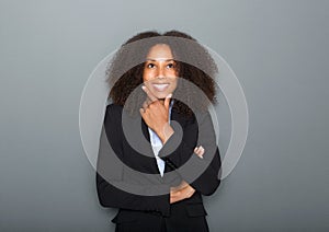 Confident young business woman thinking on gray background