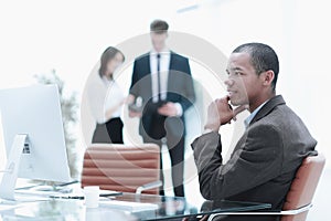 Confident young businessman on blurred background office