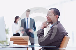 Confident young businessman on blurred background office