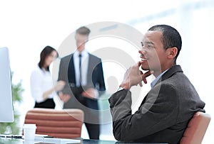 Confident young businessman on blurred background office