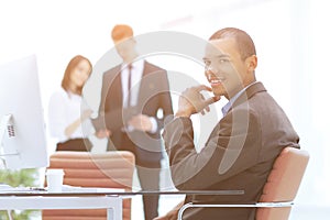 Confident young businessman on blurred background office