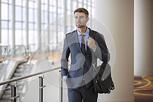 Confident Young Businessman at Hotel by Escalator business trip