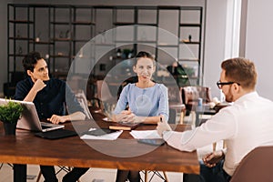 Confident young businessman presenting project to clients in office meeting