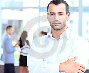 Confident young businessman standing arms crossed