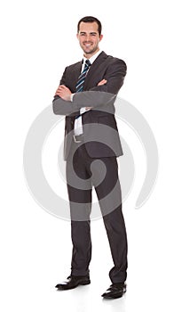 Confident young businessman standing arms crossed