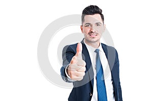 Confident young businessman wearing blue suit showing like gestu