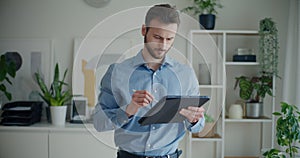 Confident young businessman writing strategy on digital tablet