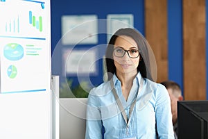 Confident young businesswoman in corporation office, wearing glasses