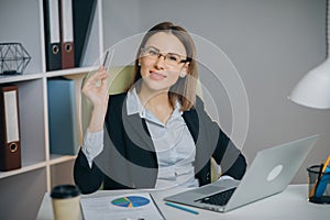 Confident Young Businesswoman Working With Data From Financial Documents at Her Workplace in Modern Office. Portait of