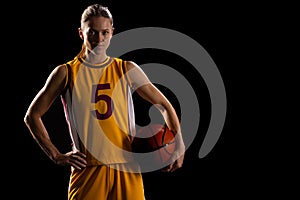 Confident young Caucasian female basketball player poses in basketball attire, with copy space on bl