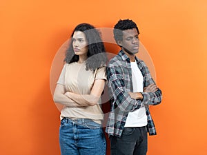 Confident Young Couple Standing Together Against Orange Backdrop