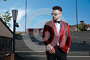 Confident young elegant man wearing red velvet tuxedo