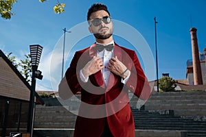 Confident young elegant man wearing red velvet tuxedo