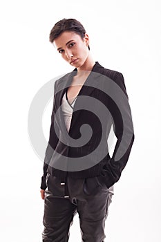 Confident young fashion model wearing black jacket and pants over white background in the studio