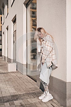 A confident young girl with a bionic prosthesis standing in the street and smiling.