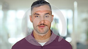 Confident young Latin business man standing in office, close up portrait.