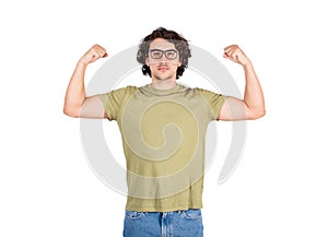 Confident young man flexing muscles imagine superpower. Strong guy wears eyeglasses shows his strength, serious face expression