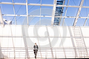 Confident young man in full suit while standing modern office hall