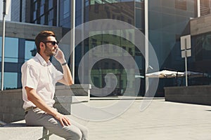 Confident young man making a phone call outdoors