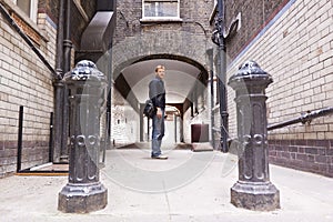 Confident young man in a ramshackle back alley