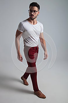 Confident young man stepping and looking sideways