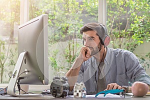 Confident young man working and concentrate on monitor while sitting at his working place in office