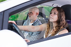Confident young woman driving car with man in passenger seat