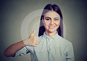 Confident young woman giving thumbs up