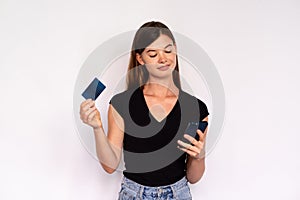 Confident young woman holding smartphone and credit card