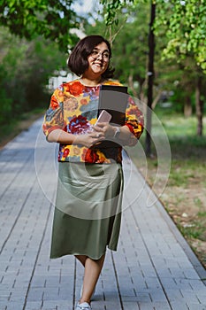 Confident young woman professional with a laptop in a vibrant city park