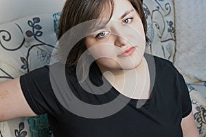 Confident young woman with short hair in her 20`s sitting in chair