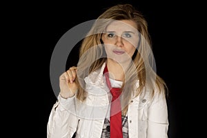 Confident young woman wearing white jacket and red tie