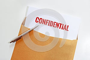 Confidential document in envelope with pen on desk.