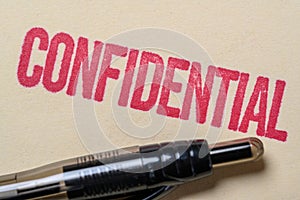 Confidential stamp on a manilla folder with a pen photo