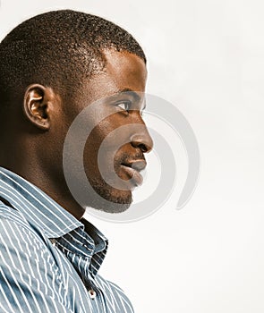 Confidently African American man delicately smiling looking at right side with textspace. Young dark-skinned businessman