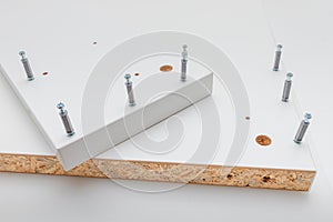 confirmatory screeds and white chipboard, as a concept of fasteners and work on the assembly of furniture at home