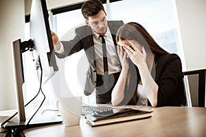Conflict, crisis and dismissal at work. Young businessman yells at subordinate female assistant after her failure photo