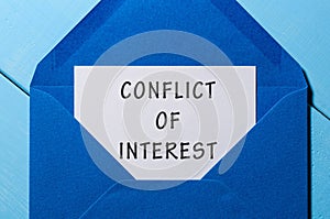 Conflict of interest text written in letter at blue envelope