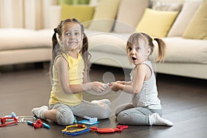 Conflict between little sisters. Kids are fighting, toddler girl takes toy, sibling relationships