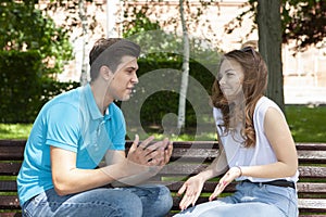 Conflicted couple not talking to each other seated on a wooden bench in park