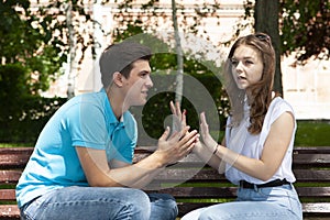 Conflicted couple not talking to each other seated on a wooden bench in park