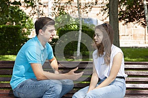 Conflicted couple not talking to each other seated on a wooden bench in park